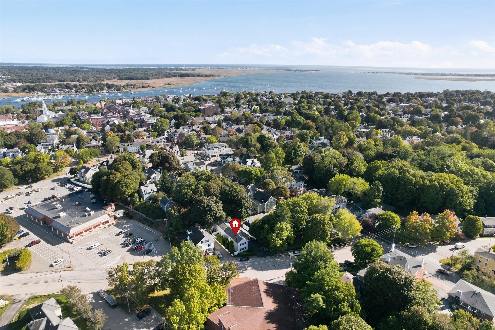 Aerial view of 2 Greenleaf St #3 among leafy homes, with Newburyport harbor in the distance.