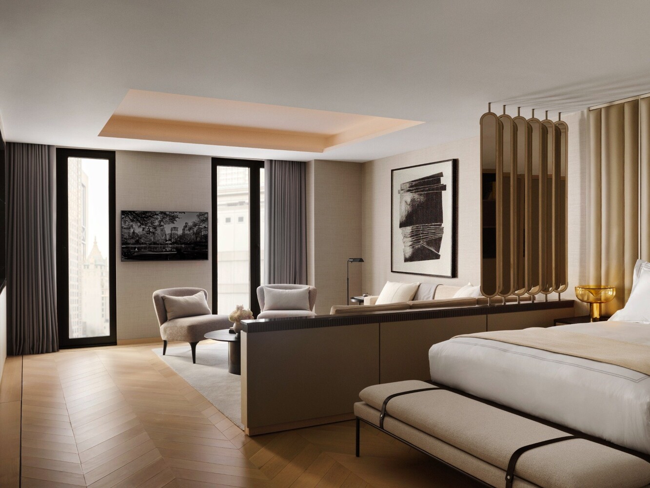 Contemporary bedroom with a white bed, brass room divider, herringbone floors, and tall city-facing windows.