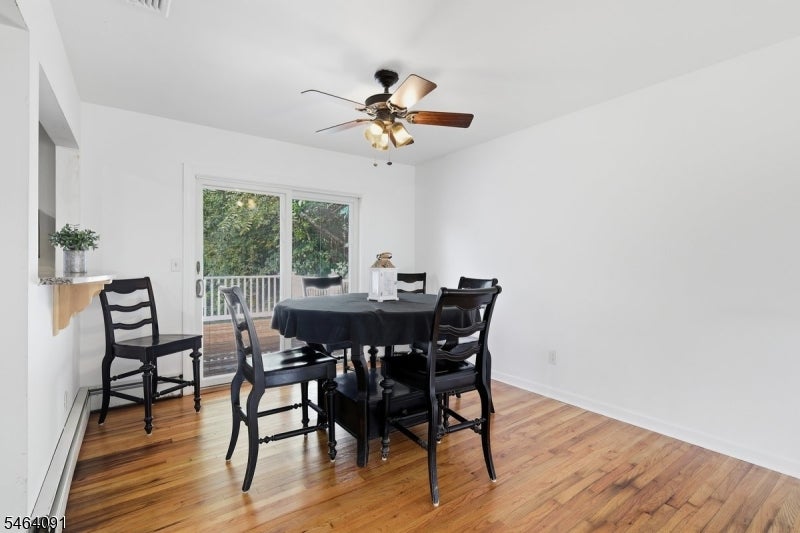 Dining room with a round table, hardwood floors, and sliding glass doors to a deck.