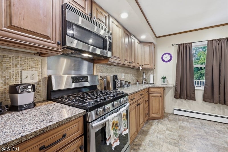 Kitchen with wood cabinets, granite countertops, and a stainless steel range.
