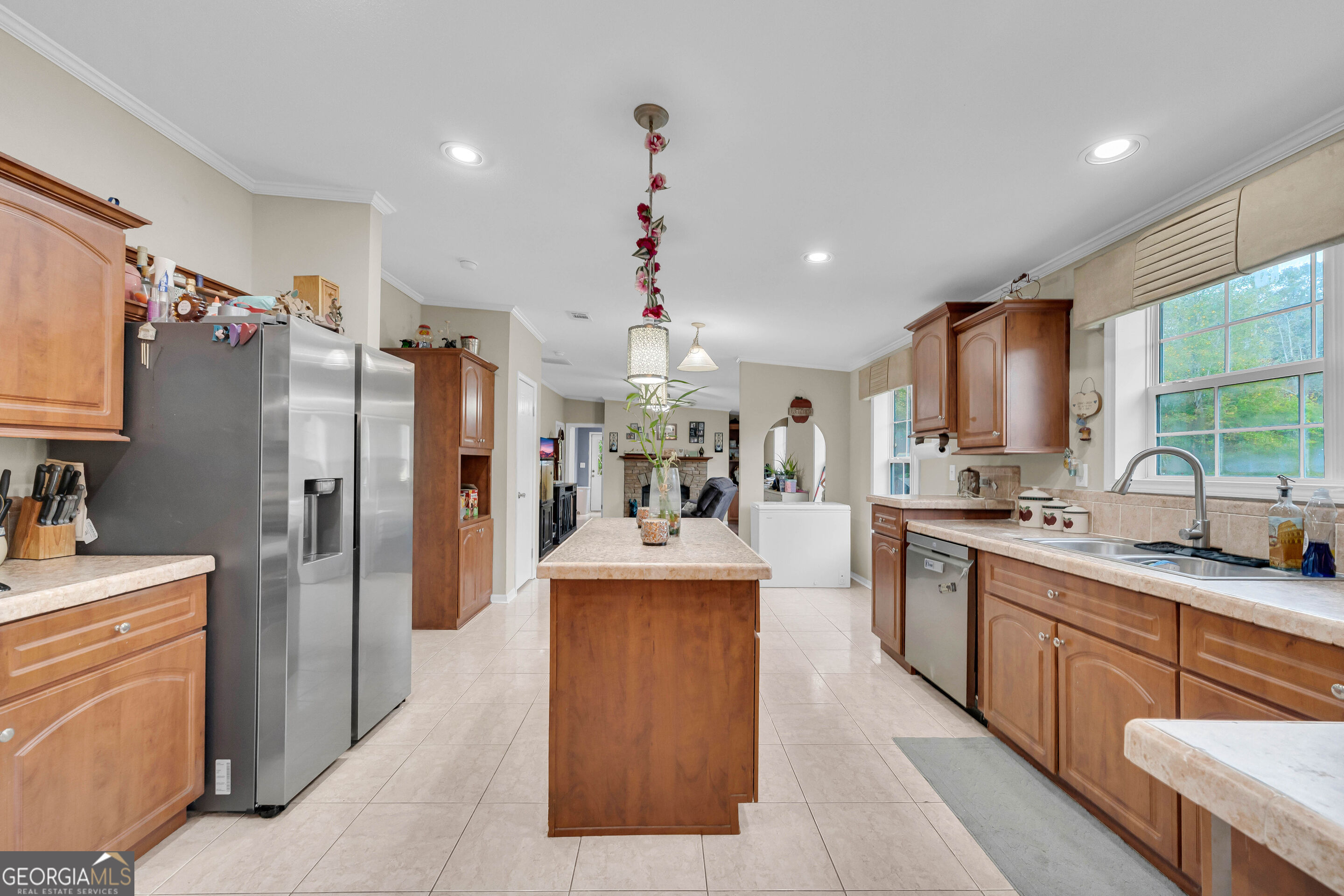 Kitchen with a large wood island, stainless steel appliances, and warm wood cabinetry.