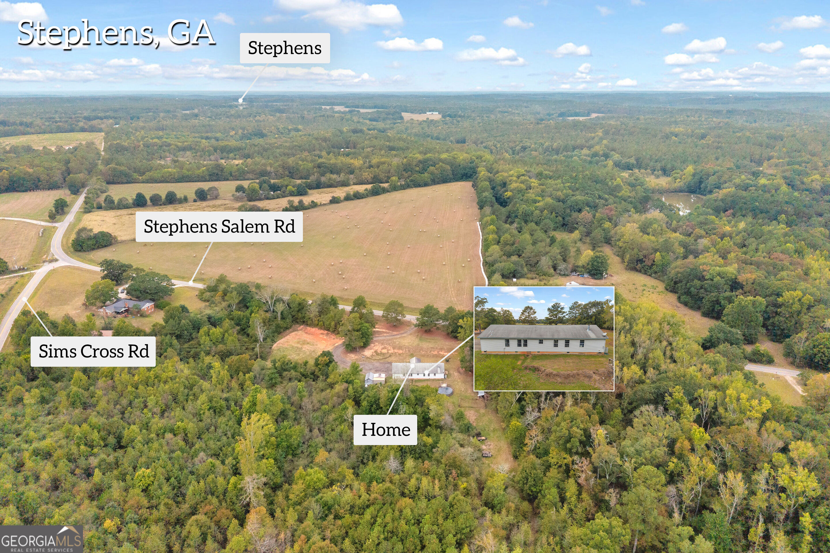 Aerial view of a home amid wooded acreage and open fields near Stephens Salem Road.