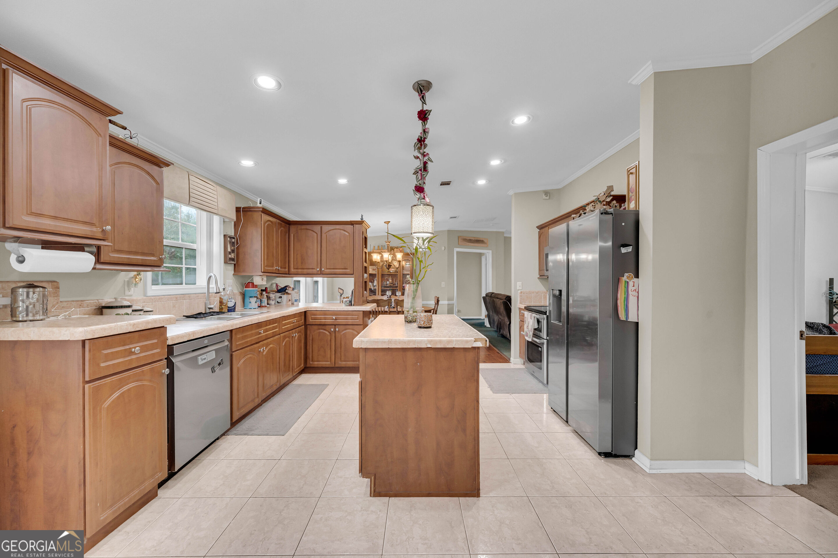 Kitchen with wood cabinets, a central island, and stainless steel refrigerator.