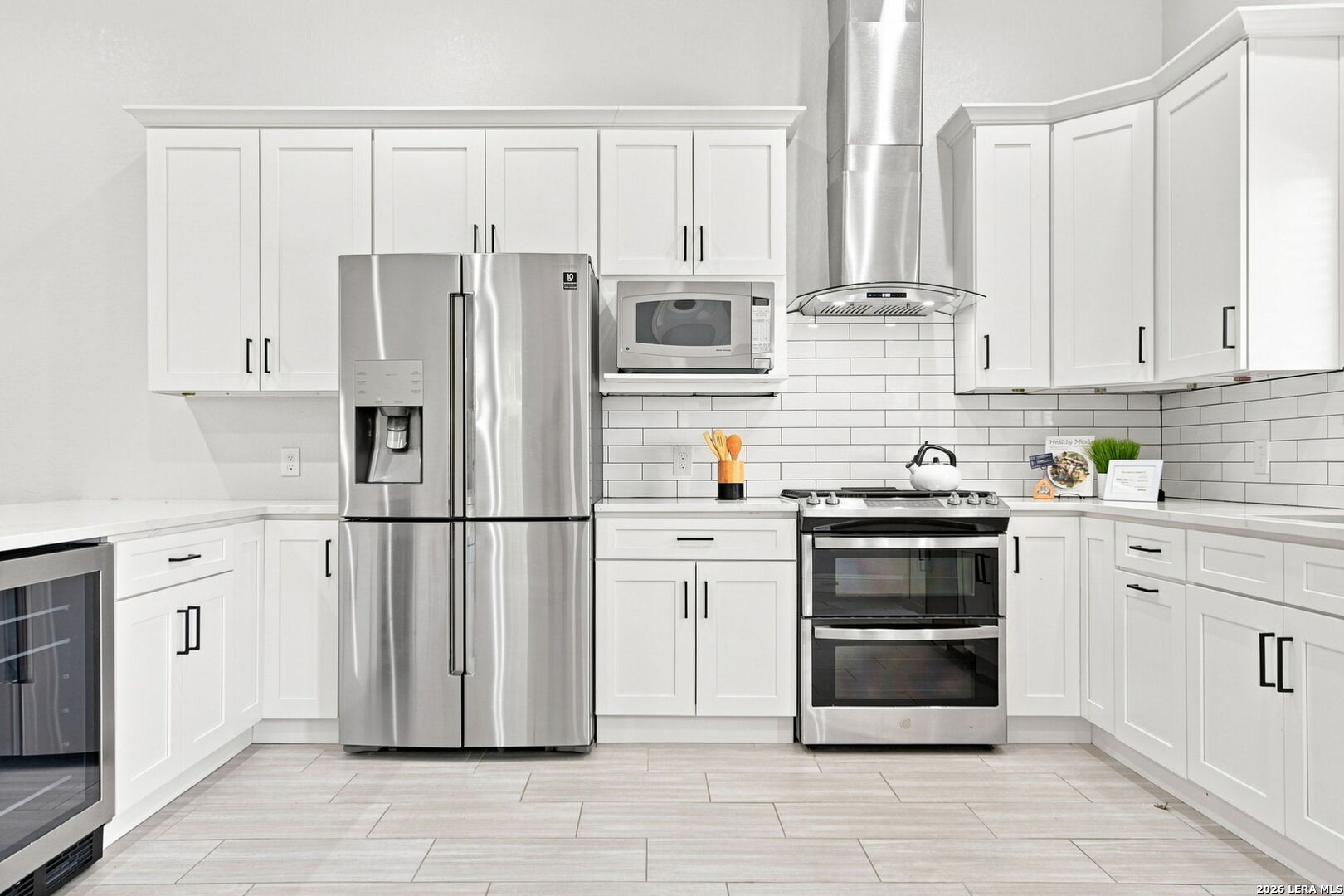 Kitchen with white shaker cabinets, stainless steel appliances, and a subway tile backsplash.