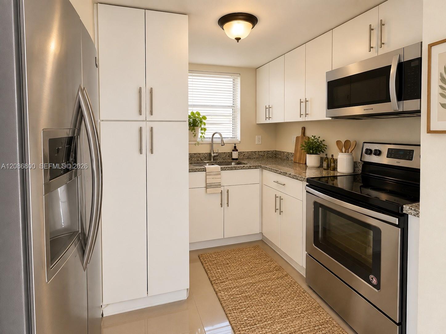 Kitchen with white cabinets, granite counters, and stainless steel appliances.