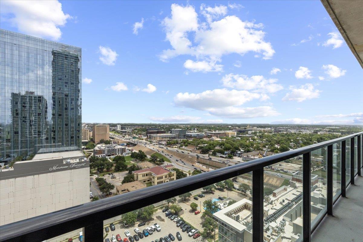 Downtown Austin skyline from a high-rise balcony, with a glass railing and Manchester Financial building in view.