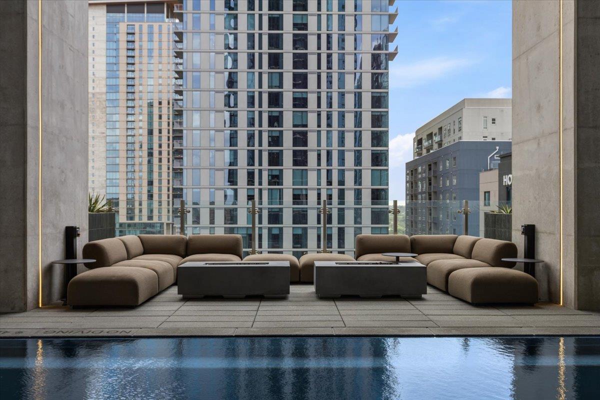 Rooftop pool lounge with curved seating and views of downtown high-rises.
