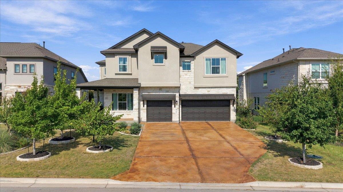 Two-story stucco and stone home with a double garage and landscaped front yard.