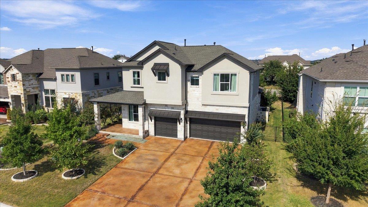 Two-story home with stone accents, a covered porch, and a wide driveway.