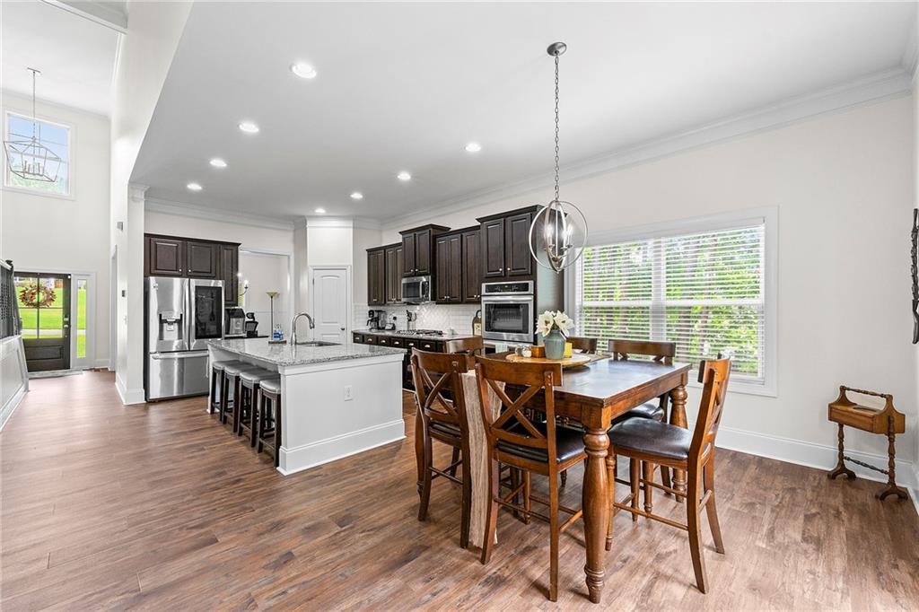 Open-plan kitchen and dining area with a large island and dark cabinets.