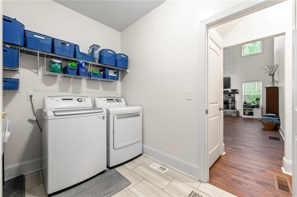 Laundry room with white washer and dryer beneath shelves of blue storage baskets.