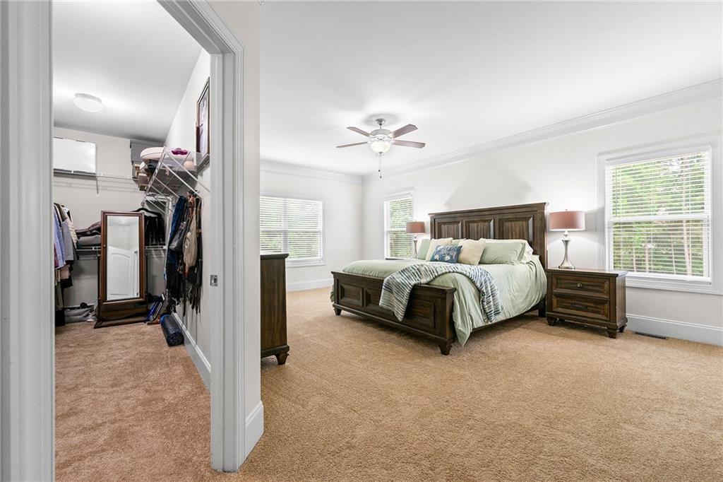 Bedroom with a dark wood bed and adjoining walk-in closet.
