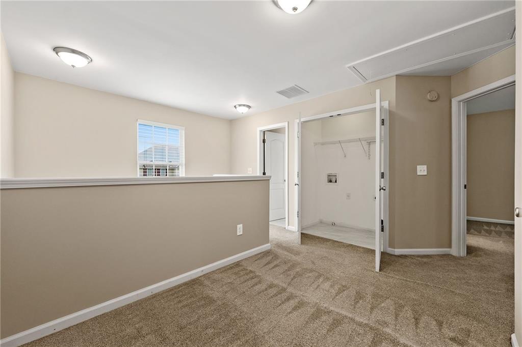 Vacant carpeted room with a window and open closet.