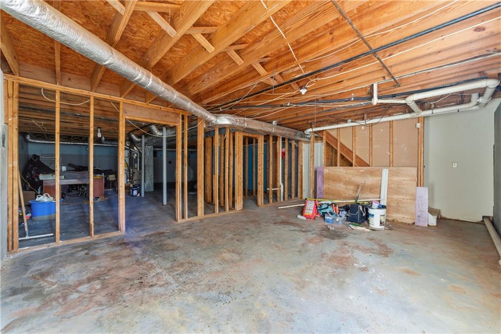 Unfinished room with exposed framing, overhead ductwork, and a concrete floor.