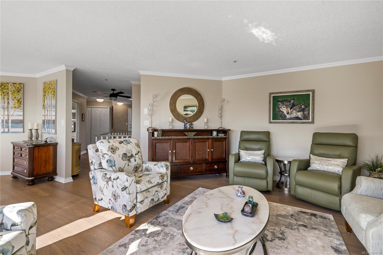 Living room with green recliners, a floral armchair, and an oval coffee table.