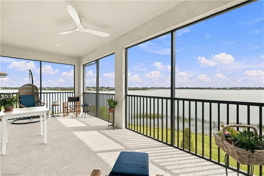 Furnished waterfront lanai with expansive windows and a wide view across the water.