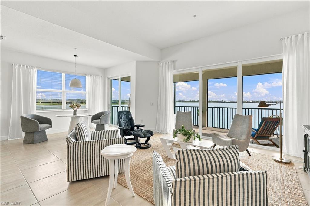 Living room with striped sofas and a wide water view through floor-to-ceiling windows.