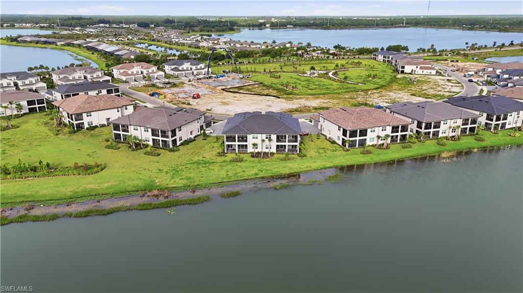 Aerial view of waterfront homes and undeveloped lots beside a broad lake.