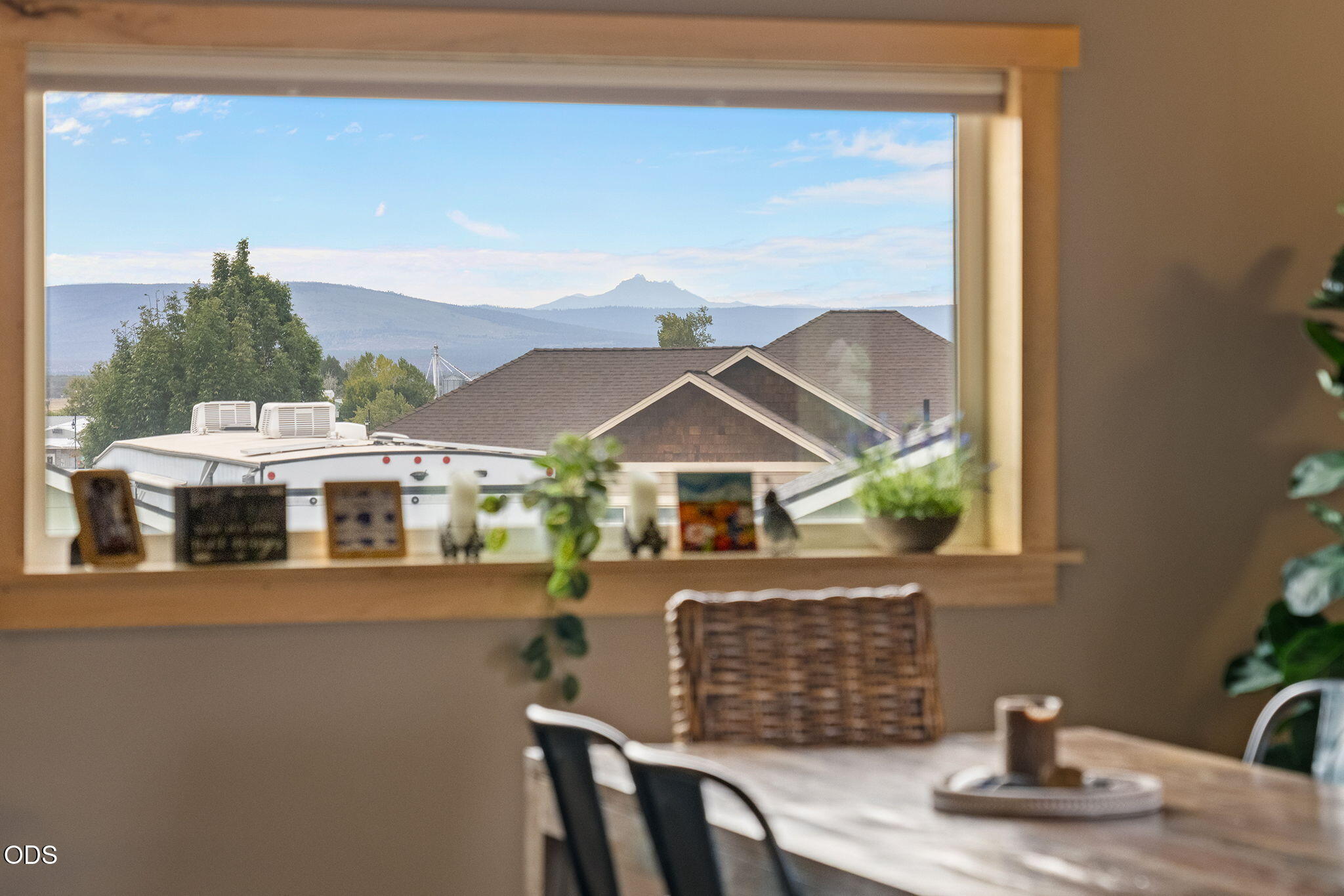 Dining area with a large window framing a distant mountain view.