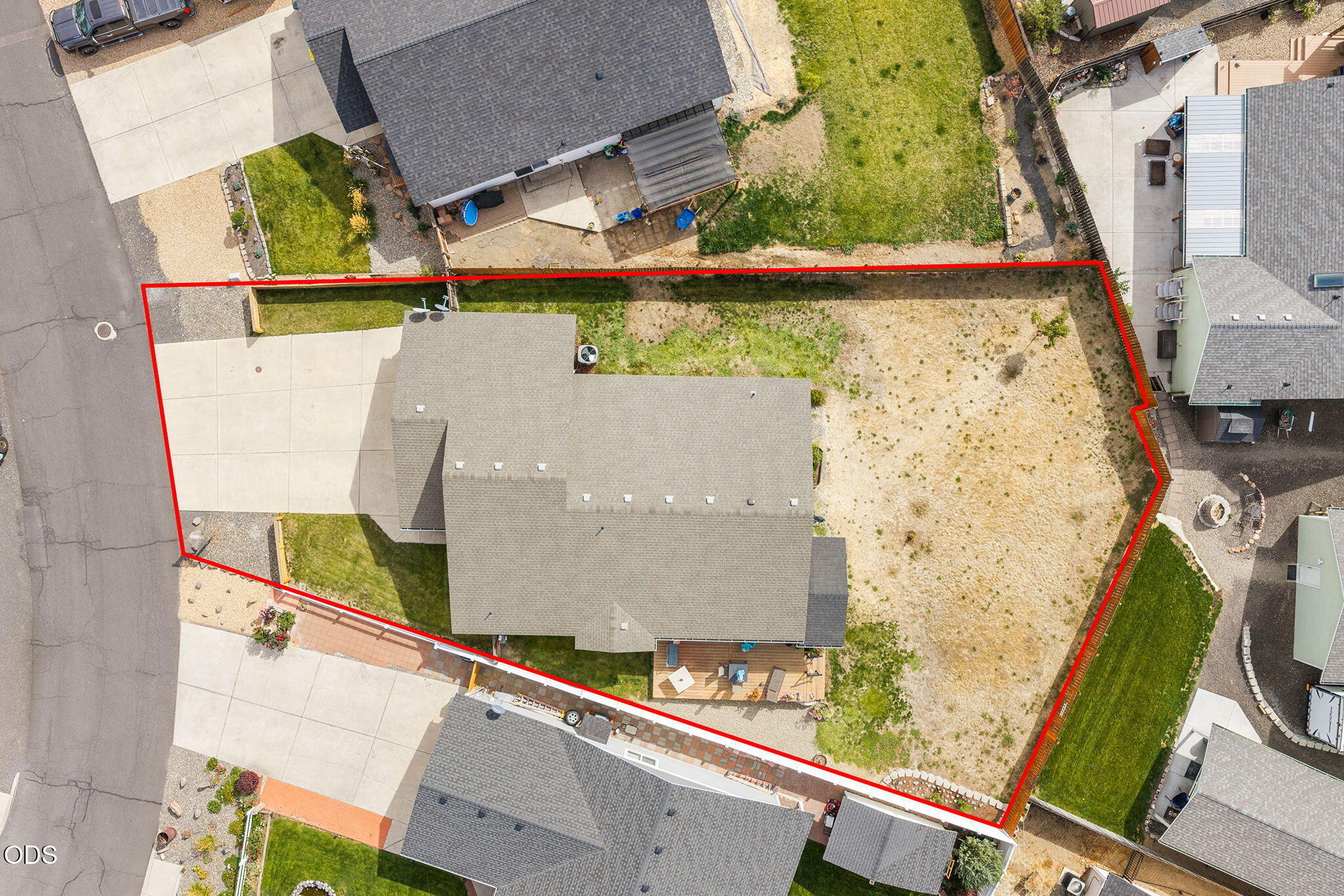 Aerial view of a house and large backyard, with the property boundary outlined in red.