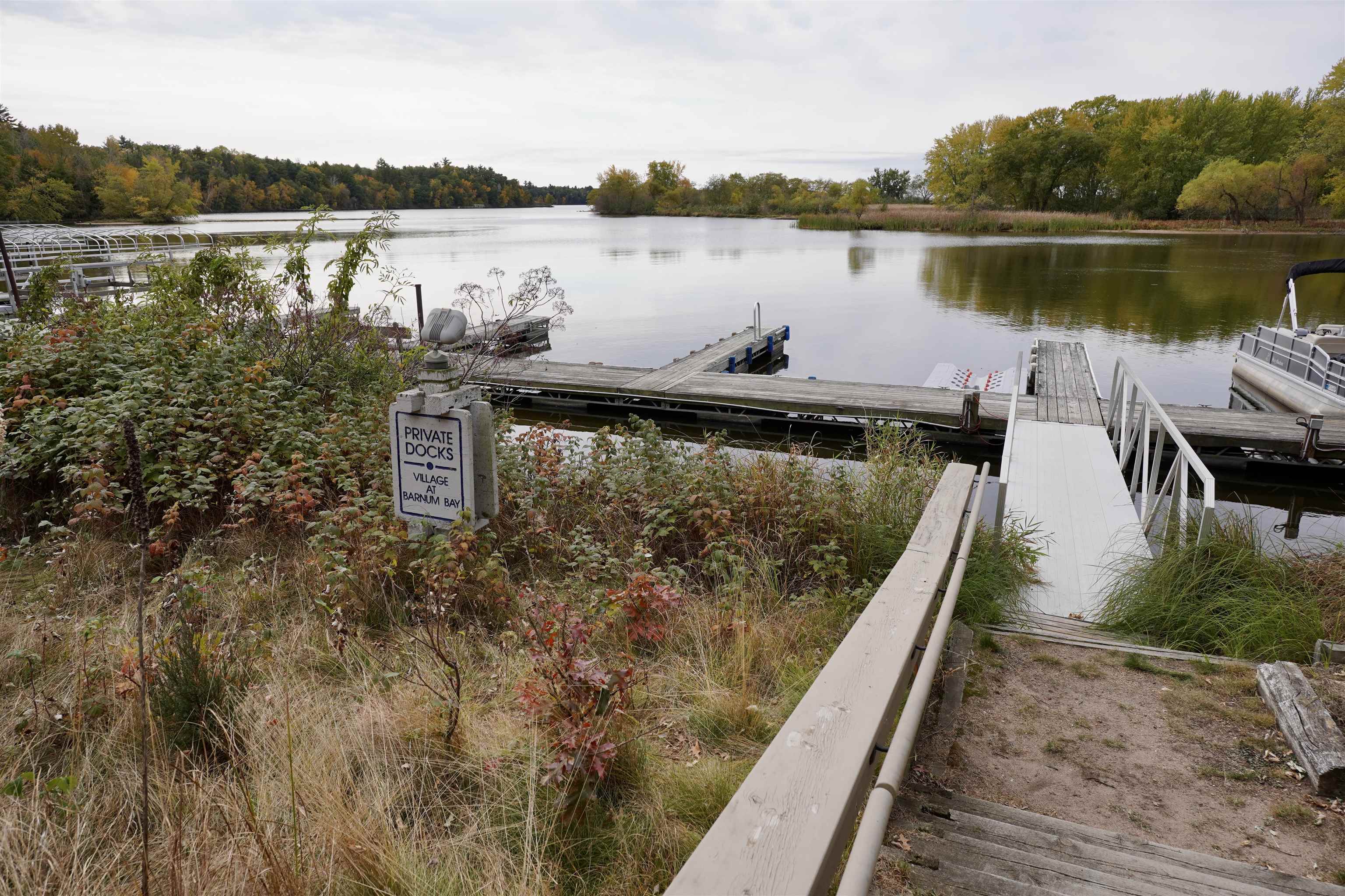 Lakeside docks with a white gangway and a sign for Village at Barnum Bay.