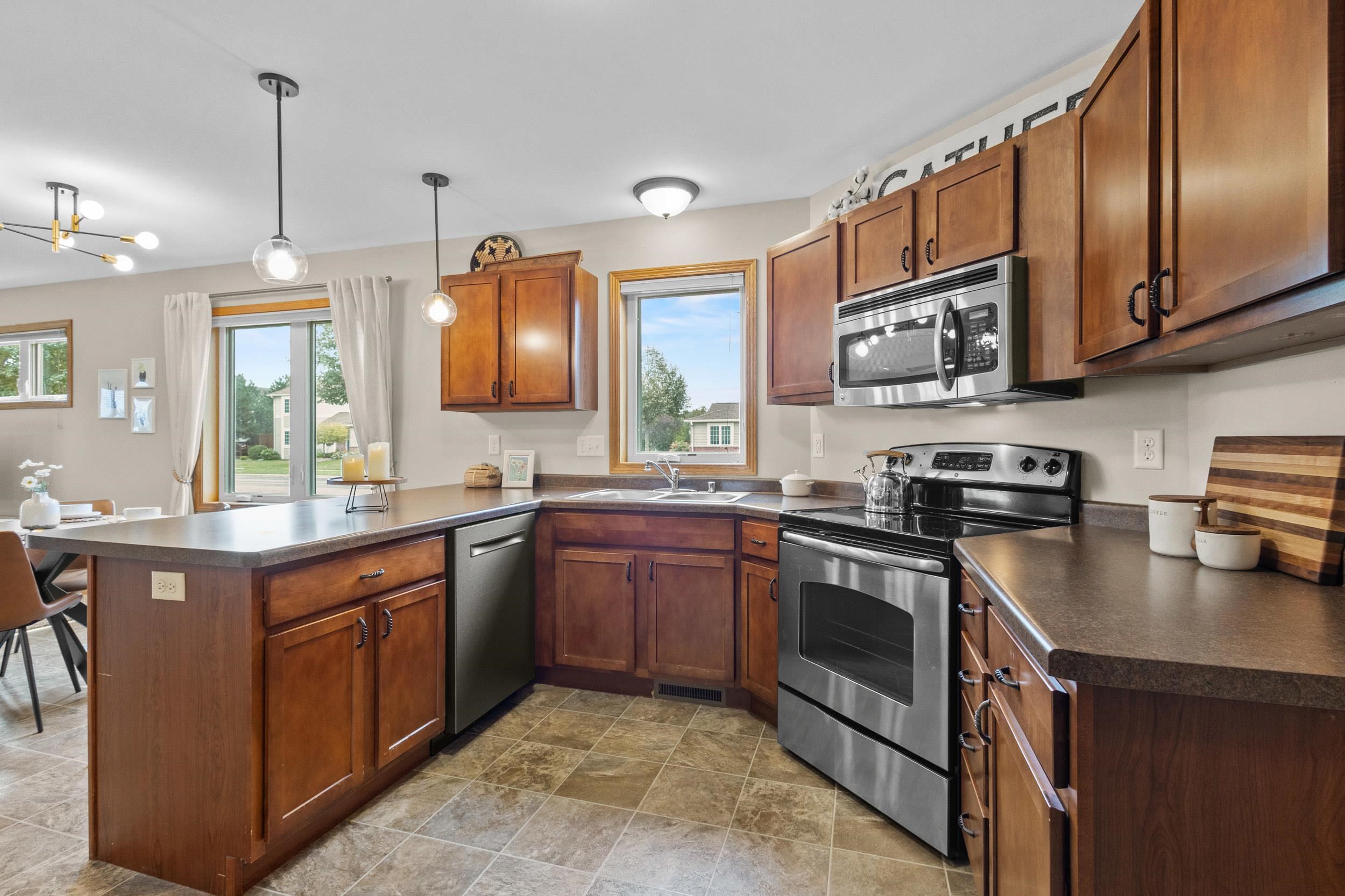 Kitchen with warm wood cabinets, a peninsula, and stainless steel appliances.