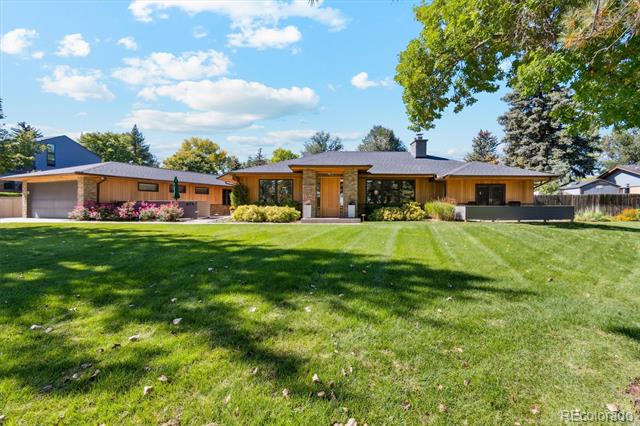 Single-story midcentury-style home with a broad lawn and mature trees.