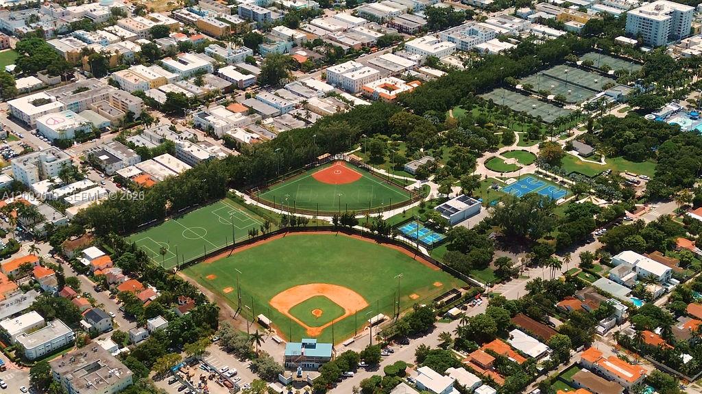 Aerial view of a city park with baseball diamonds, soccer fields, tennis courts, and surrounding homes.