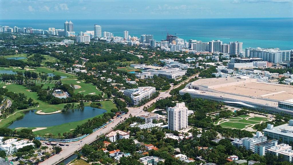 Aerial view of Miami Beach’s oceanfront skyline, with a golf course and residential neighborhoods in the foreground.