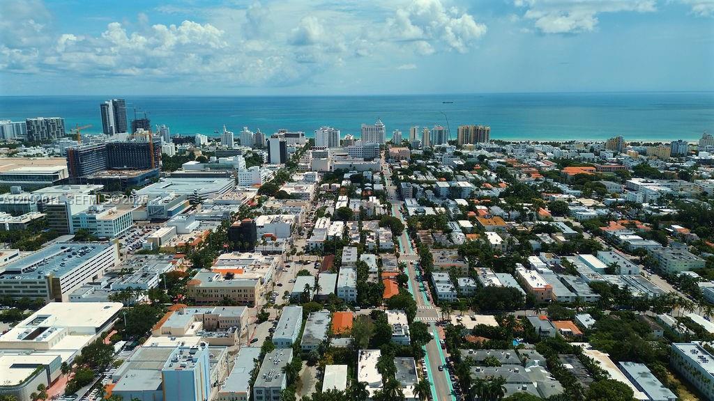 Aerial view of Miami Beach and the ocean, with coastal high-rises and streets in the foreground.