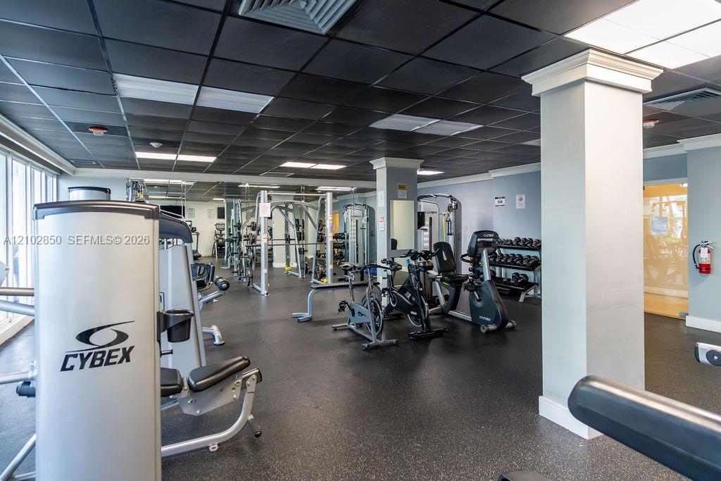 Fitness center with strength-training machines, weight racks, and stationary bikes.