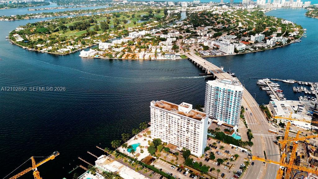 Waterfront condominium complex beside a causeway bridge, surrounded by water and marinas.