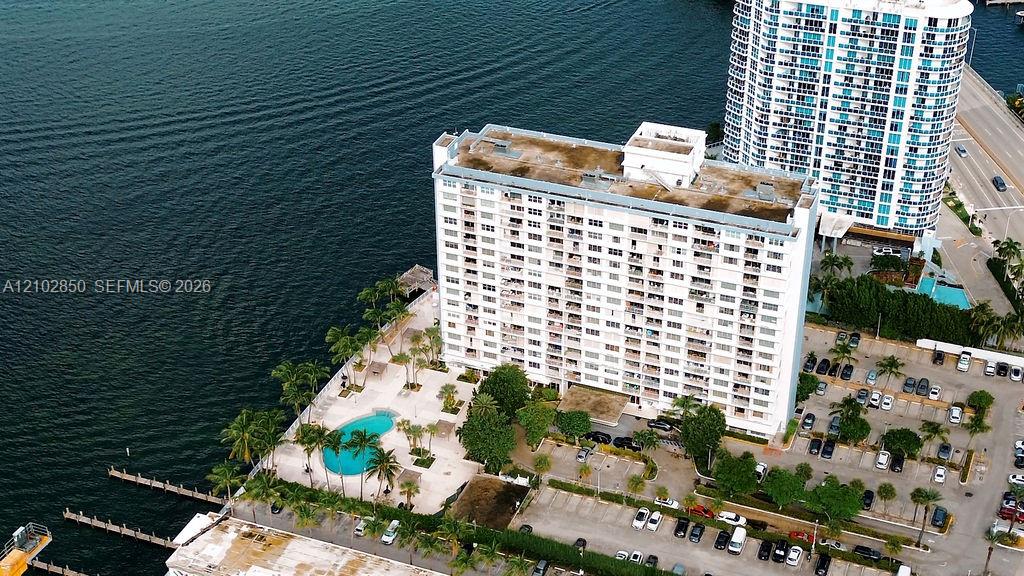 Waterfront condominium beside the bay, with a pool and palm-lined grounds.