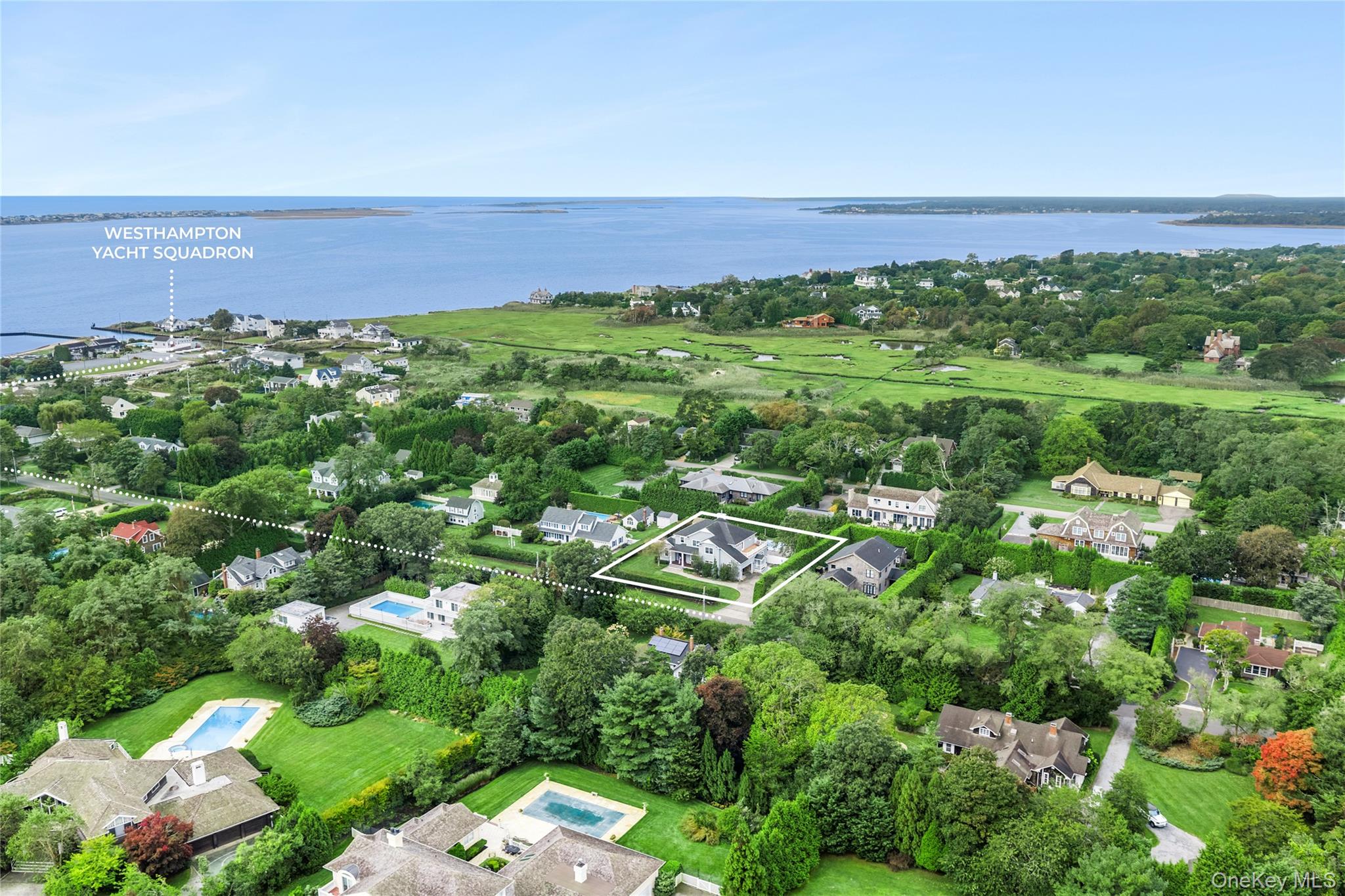 Aerial view of a highlighted Westhampton home near the water and Westhampton Yacht Squadron.
