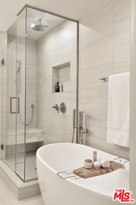 Bathroom with a freestanding tub and glass-enclosed shower.