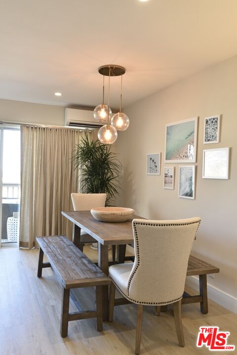 Dining area with a wooden table, bench, upholstered chairs, and pendant lights.