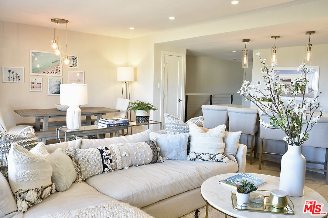 Staged living room with a cream sectional sofa and an open dining area.