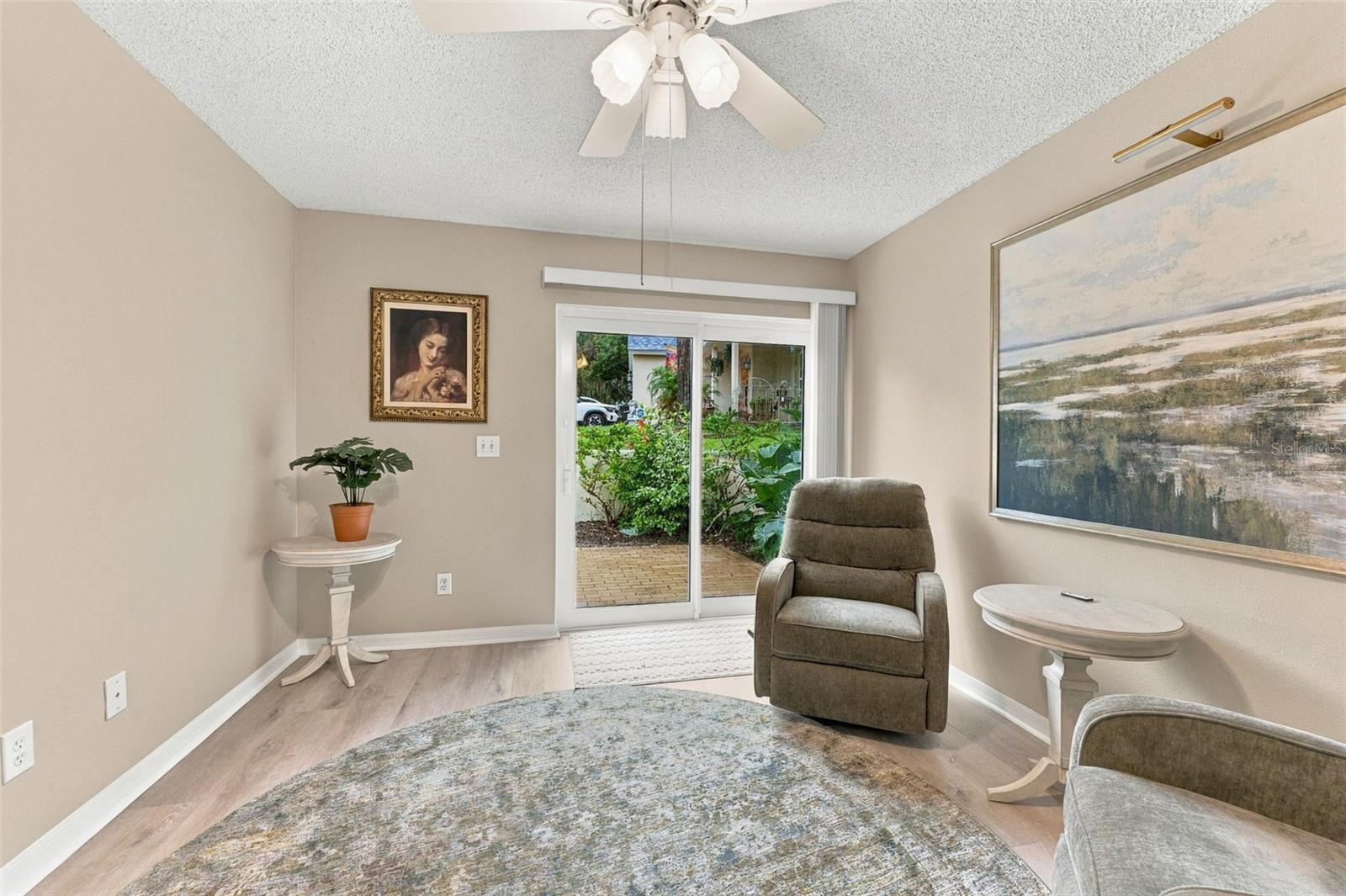 Sitting room with a recliner and sliding glass doors opening to a garden patio.