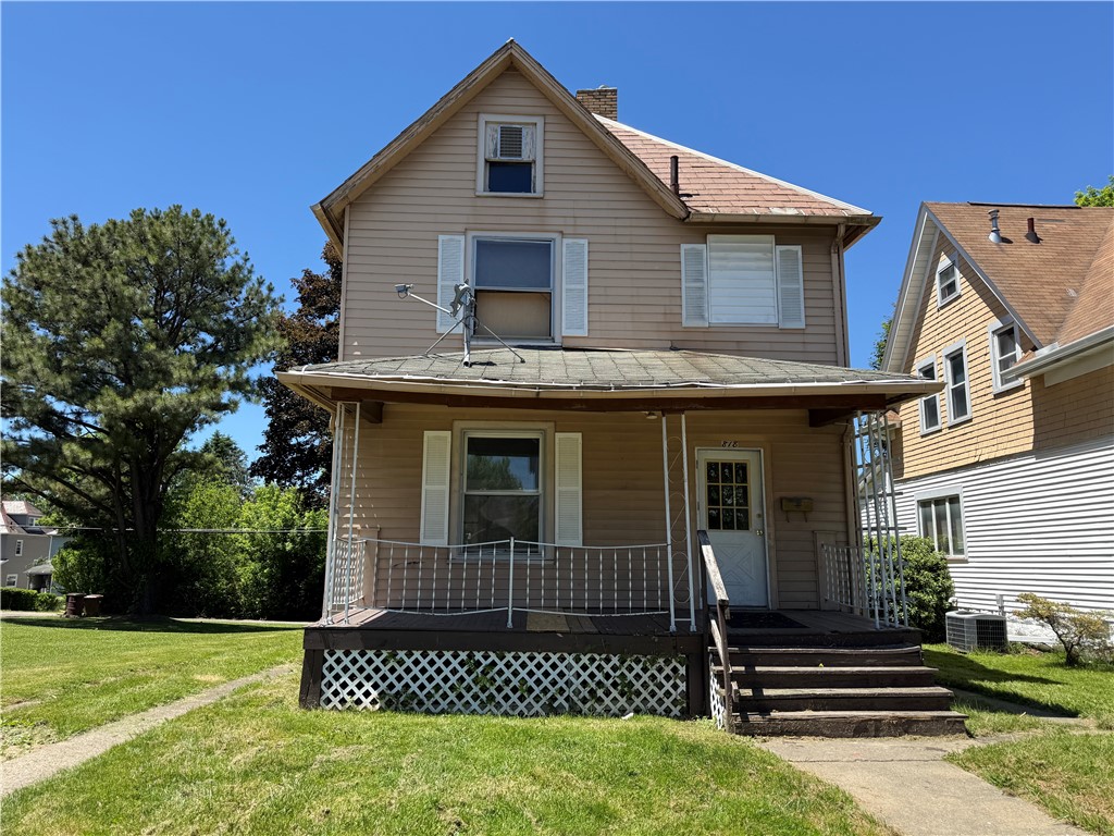 Two-story beige house with a covered front porch, white lattice skirting, and front steps.