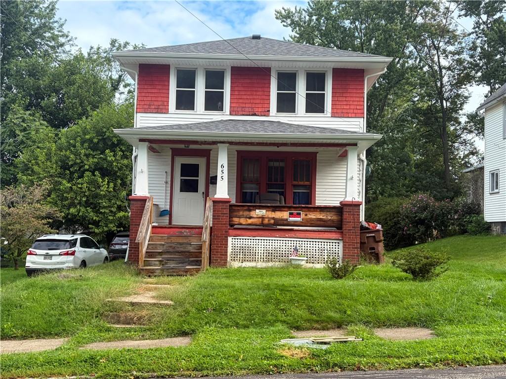 Two-story white house with red accents, a covered porch, and a front lawn.
