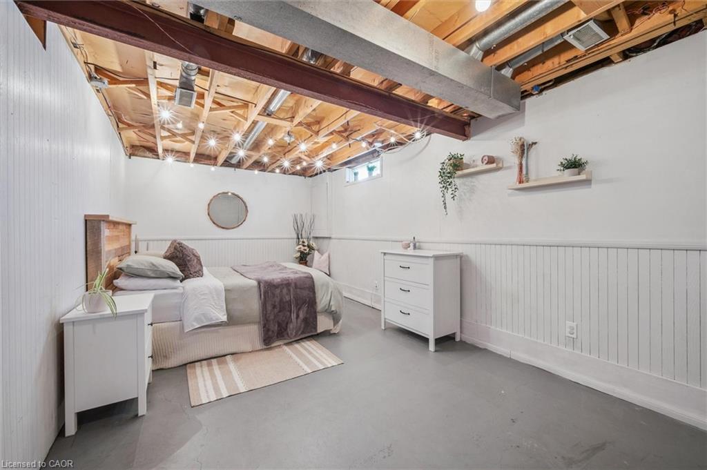 Bedroom with a bed beneath exposed ceiling joists and ductwork.