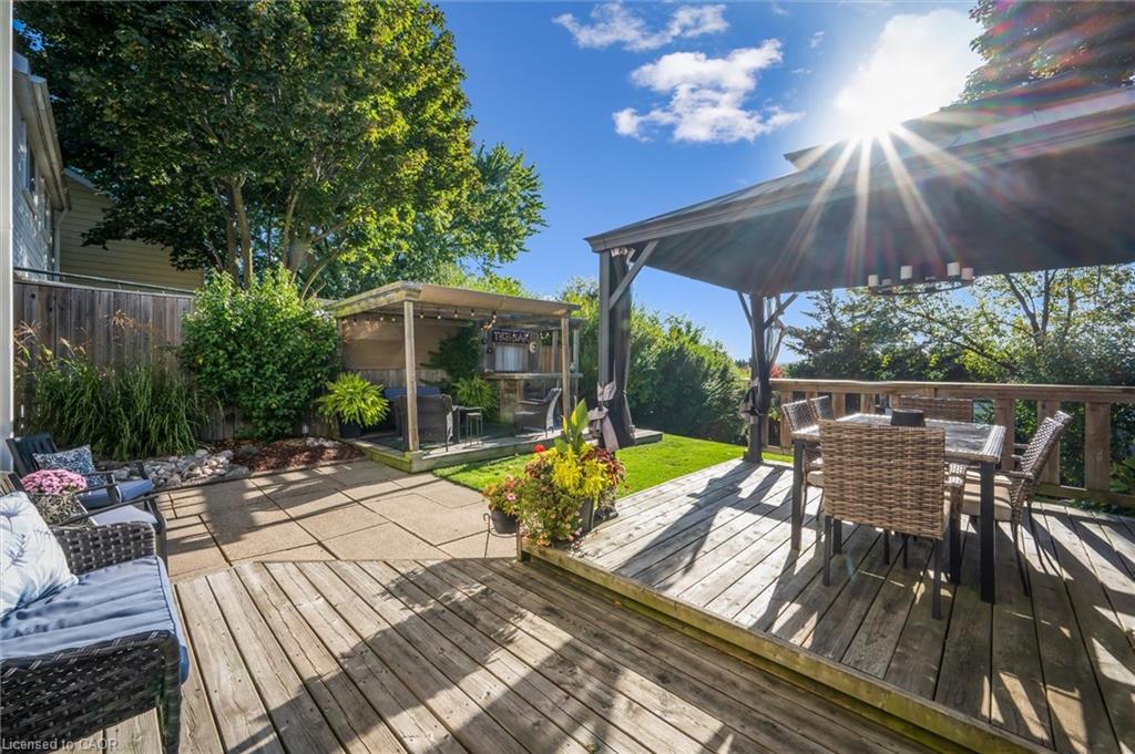 Backyard deck with a covered dining area, gazebo, and garden seating.