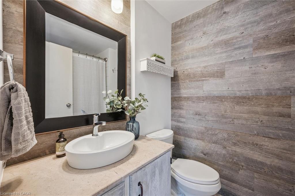 Bathroom with a vessel sink, dark-framed mirror, and gray wood-look accent wall.