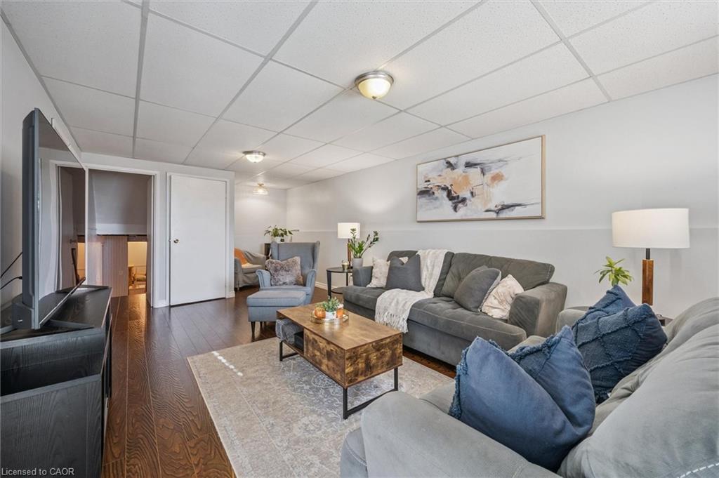 Furnished living room with gray seating, a wood coffee table, hardwood floors, and abstract wall art.