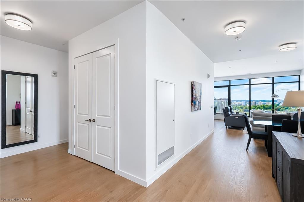 Condo entry opens to a furnished living and dining area with floor-to-ceiling city-view windows.