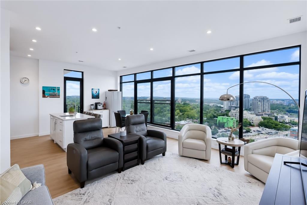 Furnished condo living room with floor-to-ceiling windows overlooking the city.