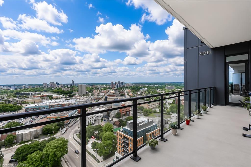 High-rise balcony with potted plants overlooking the city skyline.