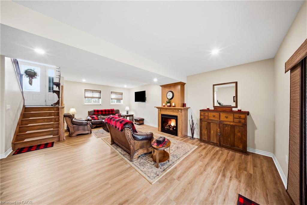 Furnished living room with a lit fireplace, leather seating, and plaid throws.