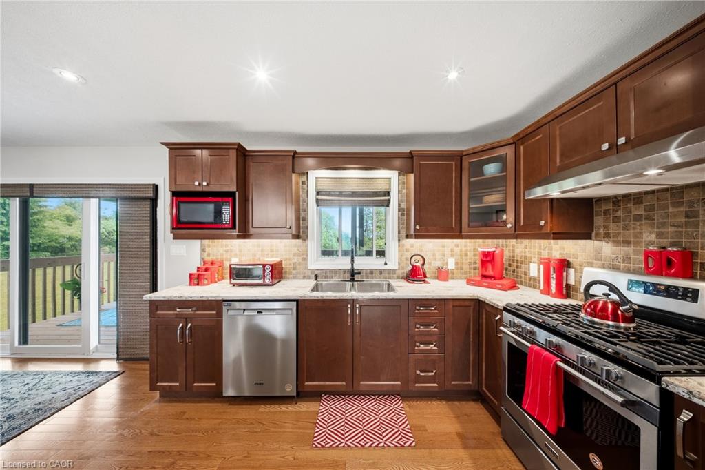 Kitchen with cherry cabinets, stone counters, stainless-steel appliances and sliding doors to a deck.