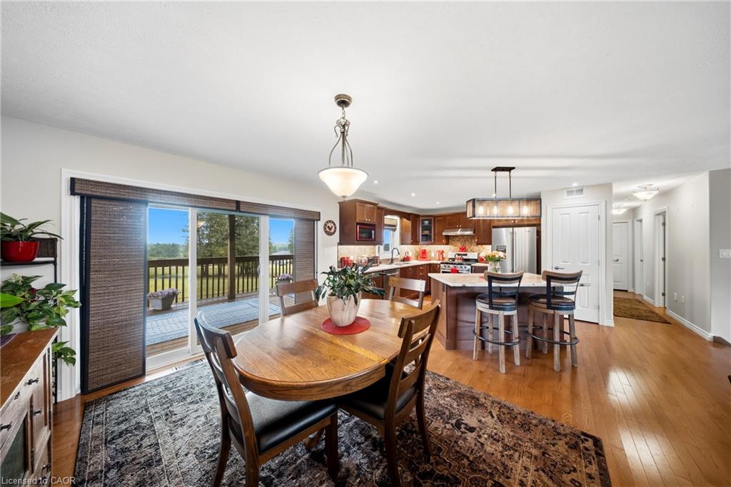 Dining room and kitchen with a round wooden table and sliding doors to a deck.
